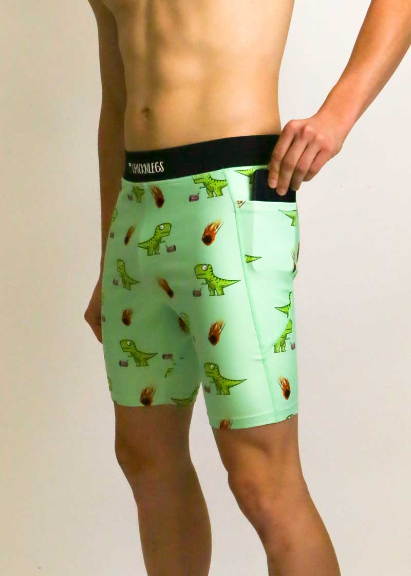 Side view of runner putting phone into pocket of the men's 8 inch dino half tights.