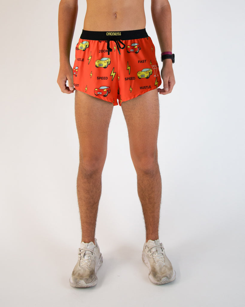 Runner is wearing ChicknLegs in the men's 2 in drawstrings split running shorts in the cars design. The print has red, yellow, fast cars with lightning bolts on it.
