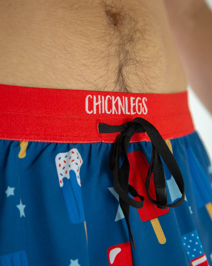 A close up shot is shown of the drawstrings tied together inside the waistband. USA Popsicles are ChicknLeg's men's 2 in drawstring in the split running shorts.