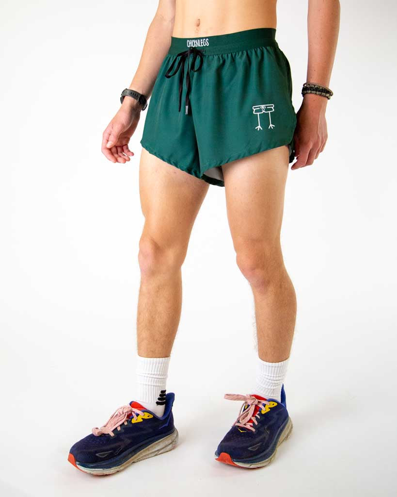 Left side view of ChicknLegs men’s 2-inch split running shorts in solid forest green, featuring split leg design for running.
