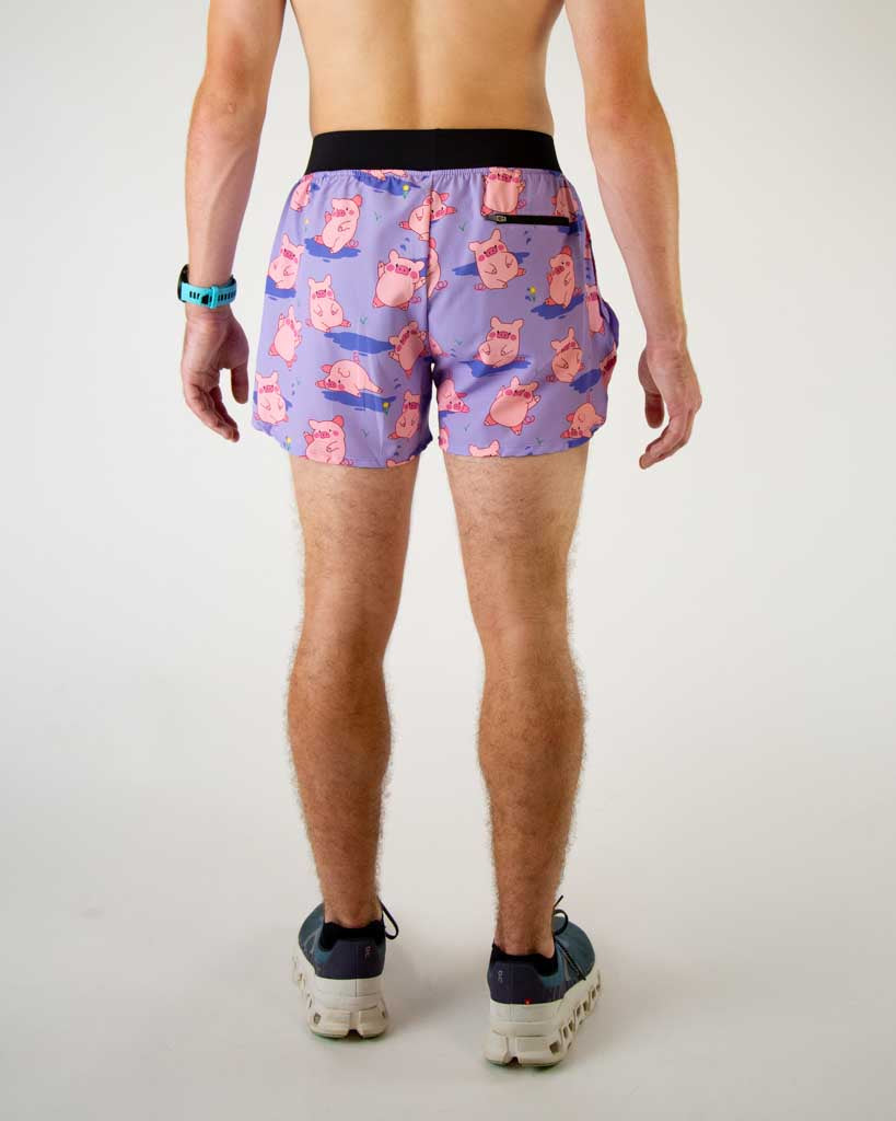 Back view of ChicknLegs men’s 4-inch split running shorts, breathable liner, lilac purple background and pink piggies on the design and a back pocket.