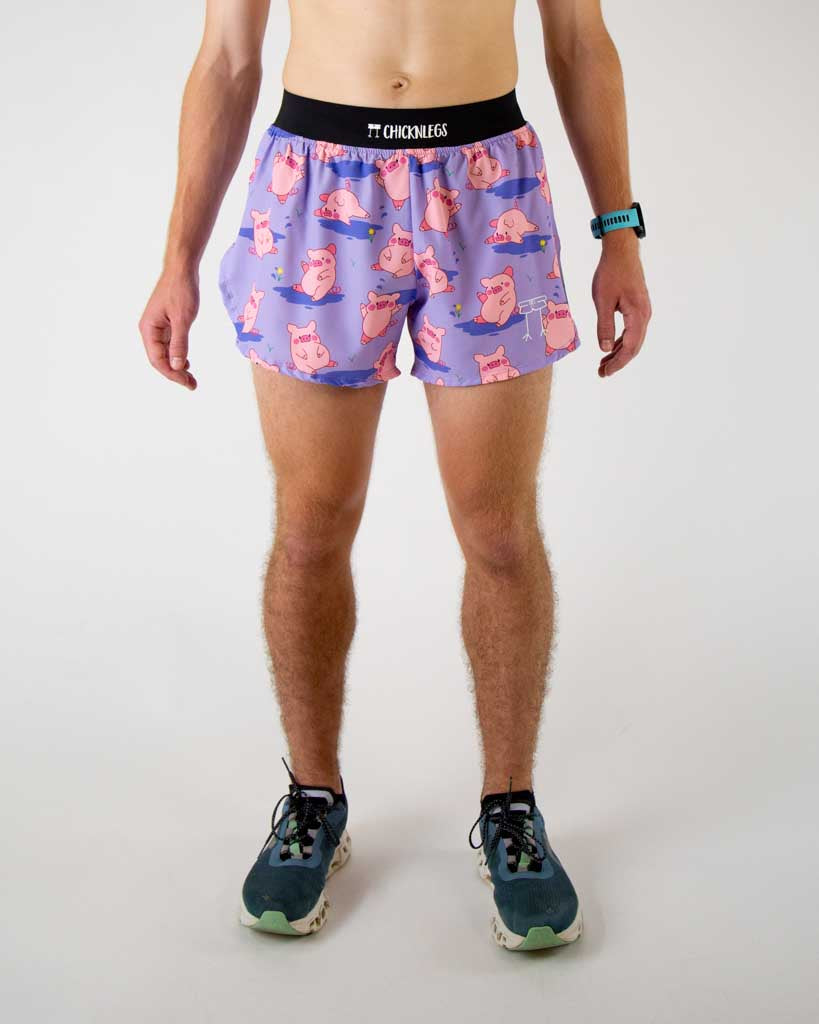 Front view of ChicknLegs men’s 4-inch split running shorts, breathable liner, lilac purple background and pink piggies on the design.