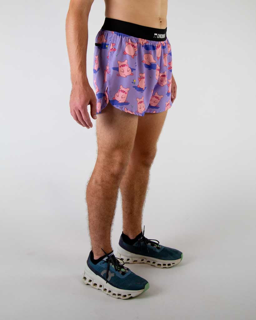 Right side view of ChicknLegs men’s 4-inch split running shorts, breathable liner, lilac purple background and pink piggies on the design.