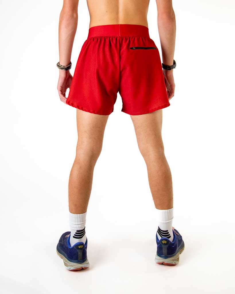 Back view of ChicknLegs men’s 4-inch split running shorts in solid cardinal red pattern, showing elastic waistband and breathable liner with back zipper pocket.