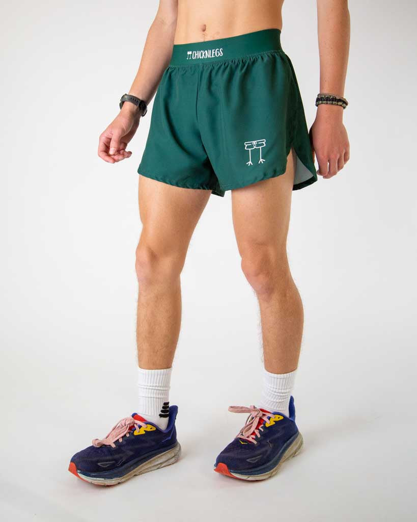Left side view of ChicknLegs men’s 4-inch split running shorts in solid forest green, featuring split leg design for running.