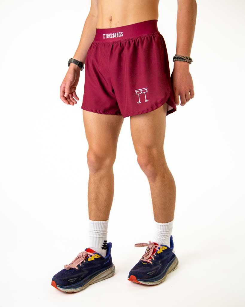 Left side view of ChicknLegs men’s 4-inch split running shorts in solid maroon color, featuring split leg design for running.