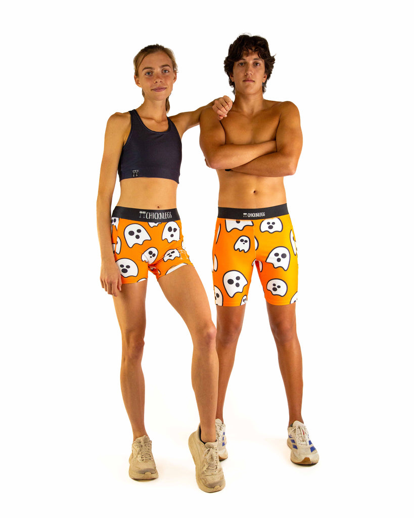 Duo image is shown of two models wearing ChicknLegs in the men's 8 inch half tight Ghost product and the Women's 3 inch compression shorts.