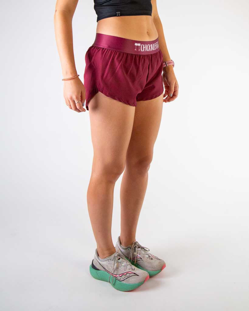 Right side view of ChicknLegs women’s 1.5-inch split running shorts in solid maroon and matching maroon waistband.