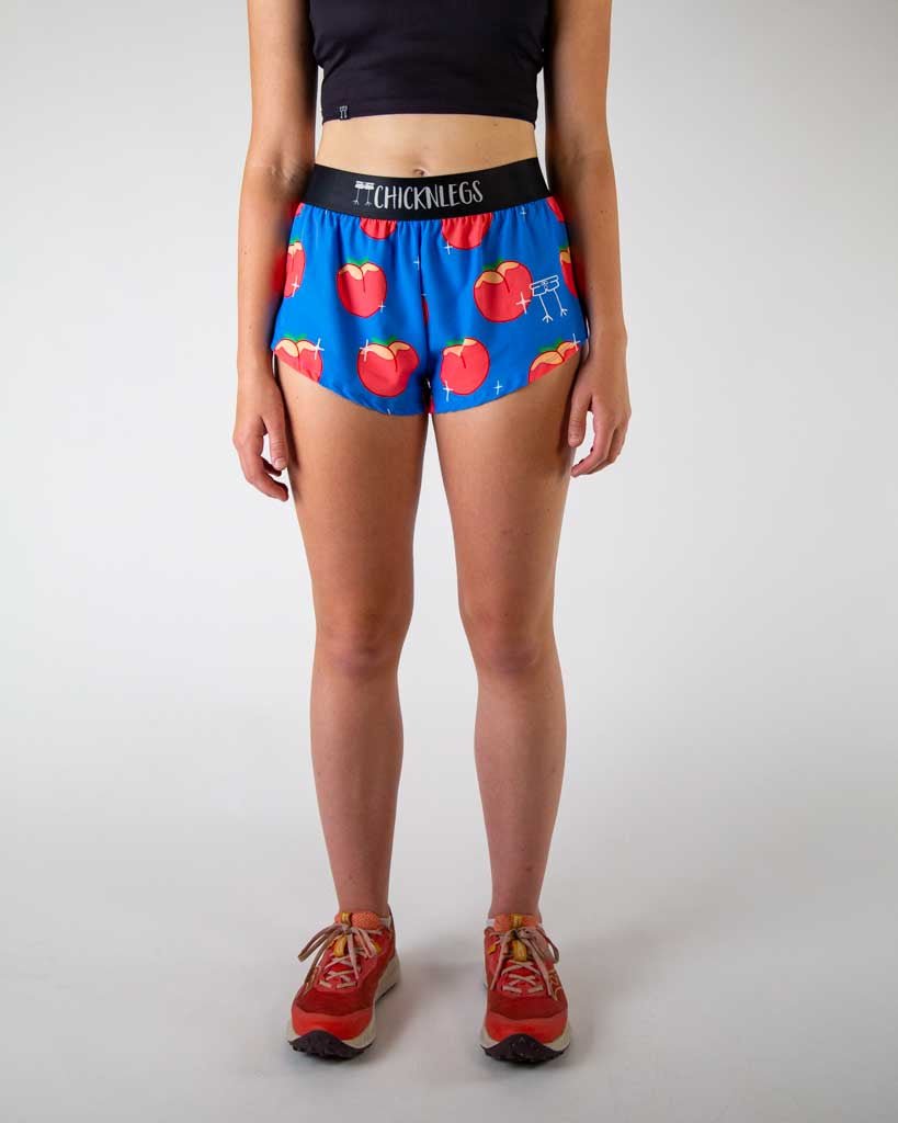 Front view of ChicknLegs women’s 1.5-inch split running shorts with drawstring, breathable liner, blue background and juicy peaches design.