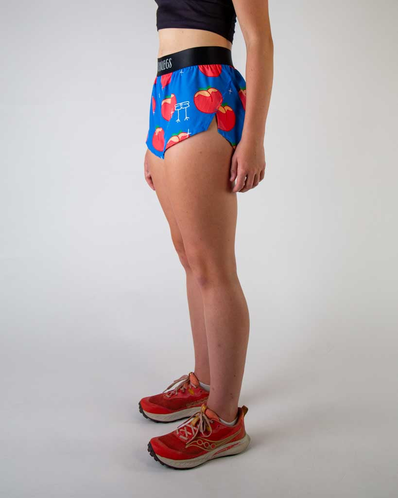 Left side view of ChicknLegs women’s 1.5-inch split running shorts with drawstring, breathable liner, blue background and juicy peaches design.