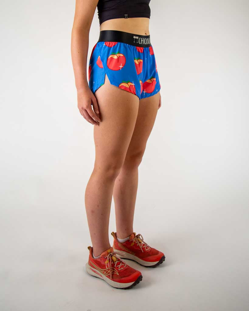 Right side view of ChicknLegs women’s 1.5-inch split running shorts with drawstring, breathable liner, blue background and juicy peaches design.