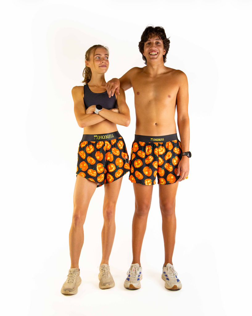 Dou image of models wearing ChicknLegs women's 4 inch split running shorts and men's 4 inch split running shorts in the Pumpkin design with matching black sports bra and white shoes.
