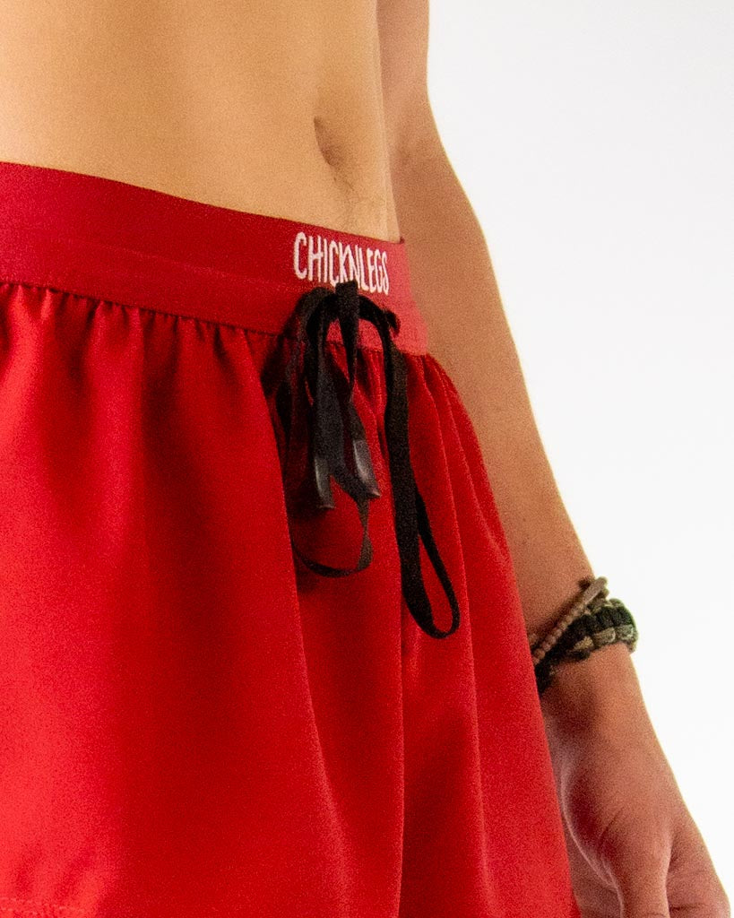 Close-up detail of ChicknLegs men’s 2-inch running shorts, solid cardinal red pattern and drawstring waistband.