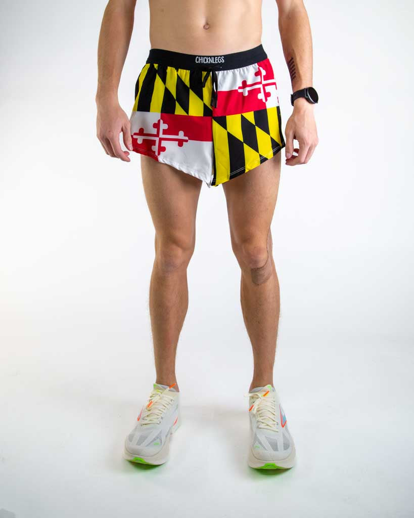 Front view of ChicknLegs Men’s 2-inch DS Split Running Shorts featuring a soft elastic drawstring waistband for a smooth, secure fit and black mesh liner for coverage and breathability. Featured are the Maryland State Flag shorts in red, white, yellow and black.