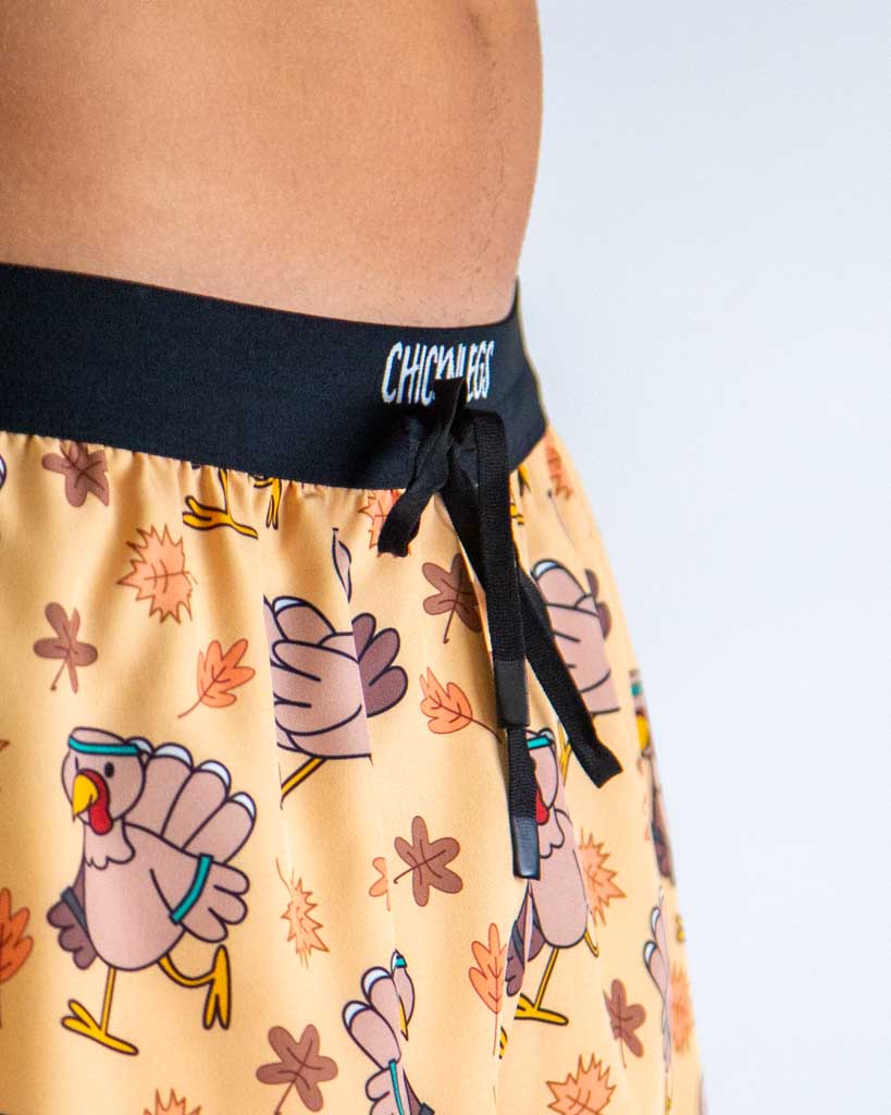 Close-up detail of ChicknLegs men’s 2-inch with drawstring running shorts, lightweight fabric with a thanksgiving turkey pattern and black waistband.