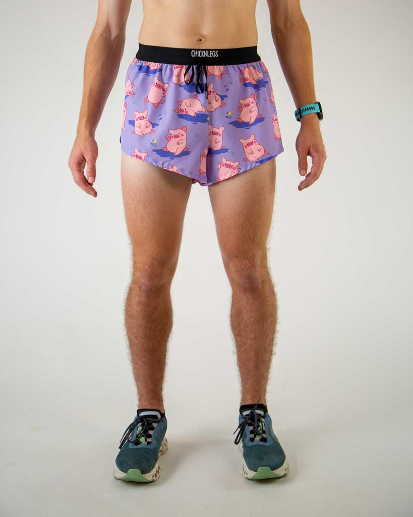 Front view of ChicknLegs men’s 2-inch split running shorts with drawstring, breathable liner, lilac purple background and pink piggies design.