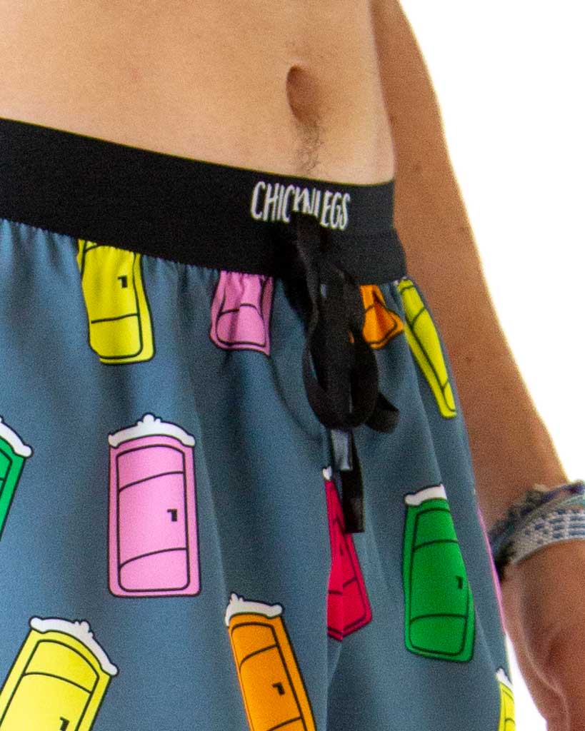 Close-up detail of ChicknLegs men’s 2-inch running shorts, blue fabric with porta potty pattern and drawstring waistband.
