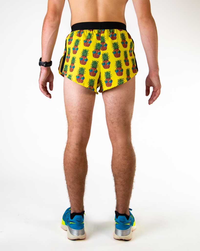Back view of ChicknLegs men’s 2-inch split running shorts in yellow with pineapple pattern, showing elastic waistband and breathable liner.