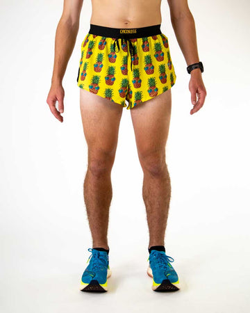 Front view of ChicknLegs men’s 2-inch split running shorts with drawstring, breathable liner, yellow background and pineapple design.