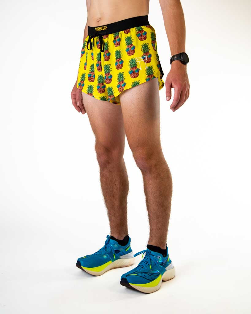 Left side view of ChicknLegs men’s 2-inch split running shorts in yellow with pineapples, featuring split leg design for running.