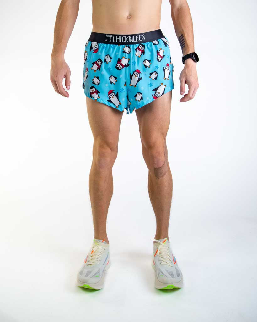Front view of ChicknLegs Men’s 2-inch Split Running Shorts featuring a soft elastic waistband for a smooth, secure fit and black mesh liner for coverage and breathability featured in the penguin design for christmas with santa hats.