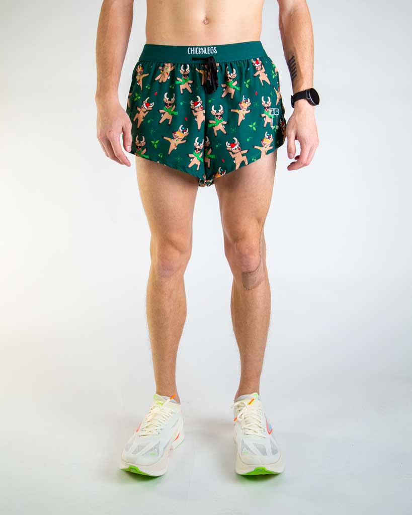 Front view of ChicknLegs Men’s 2-inch DS Split Running Shorts featuring a soft elastic drawstring waistband for a smooth, secure fit and black mesh liner for coverage and breathability. Featured are the rockin reindeer design, with reindeer wearing christmas lights, santa hats, and sunglasses with a dark green background.