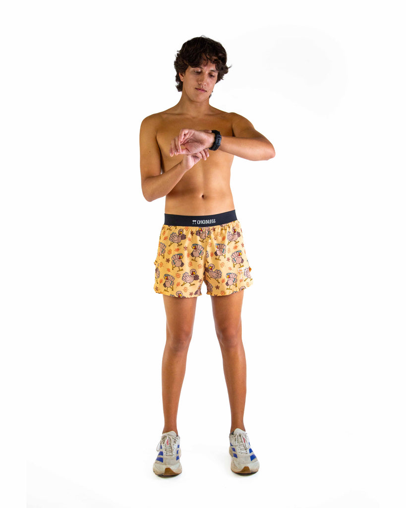 Full body view of model wearing ChicknLegs men’s 4-inch split running shorts featuring a soft elastic waistband, rear zipper pocket, and black mesh liner for full coverage and breathability in the Pardoned Turkey design, paired with a black waistband.