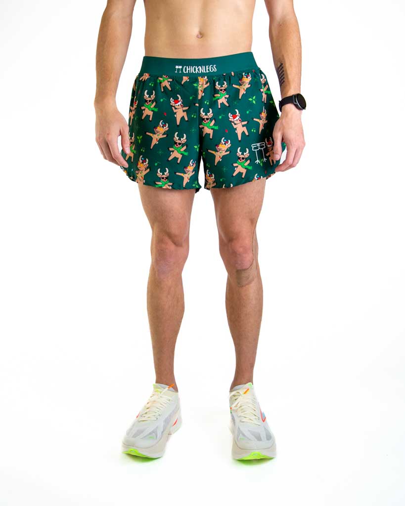 Front view of ChicknLegs men’s 4-inch split running shorts featuring a soft elastic waistband for a secure, smooth fit and black mesh liner for comfort and coverage. Featured are the dancing, rocking reindeer in christmas lights and santa hats on a dark green background.