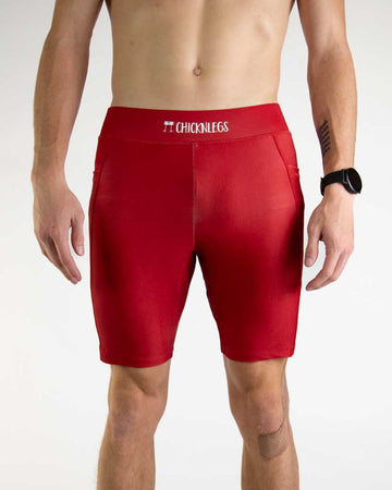 Front close up view of ChicknLegs Men’s 8-inch Half Tights featuring a soft elastic waistband for a smooth, secure fit and black mesh liner for support and comfort. Featured are the Cardinal Red solid color!