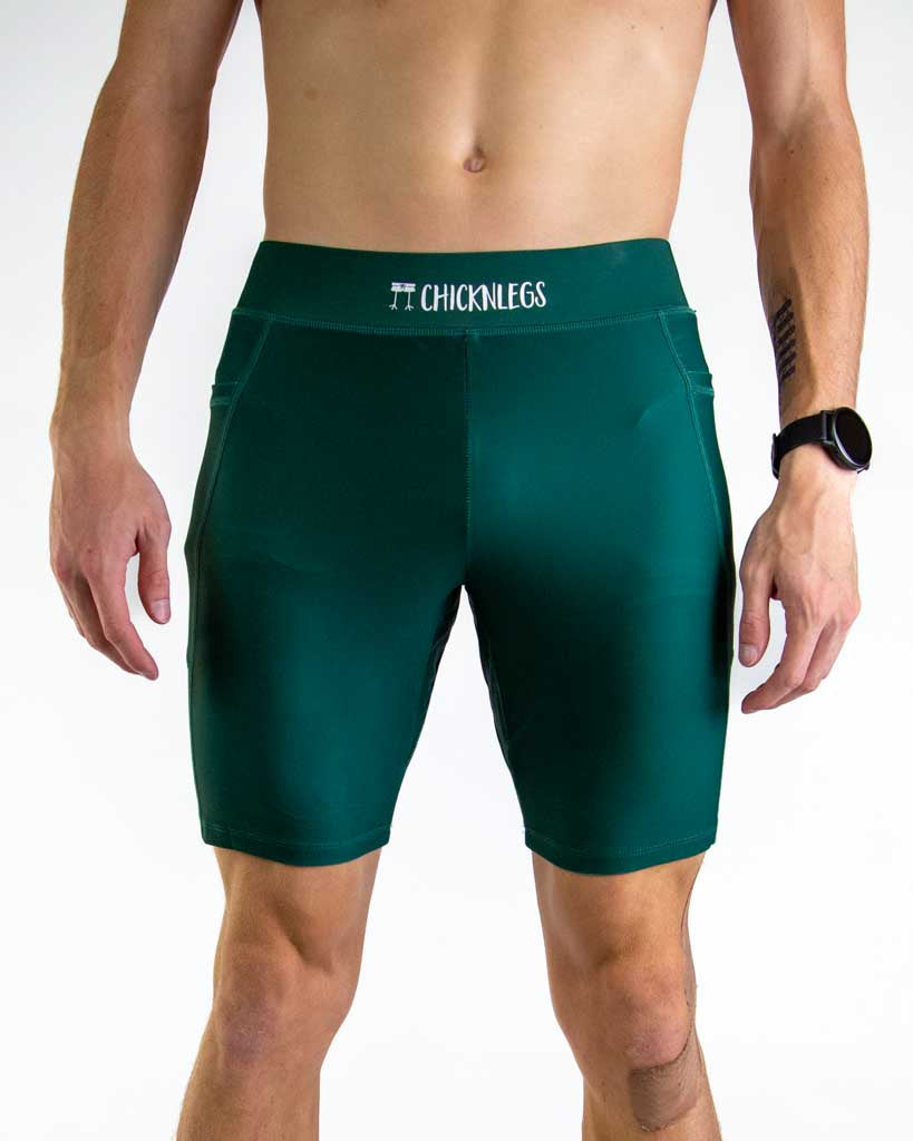 Front close up view of ChicknLegs Men’s 8-inch Half Tights featuring a soft elastic waistband for a smooth, secure fit and black mesh liner for support and comfort. Featured are the Forest Green solid color.