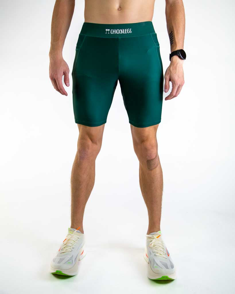Front view of ChicknLegs Men’s 8-inch Half Tights featuring a soft elastic waistband for a smooth, secure fit and black mesh liner for support and comfort. Featured are the Forest Green solid color.