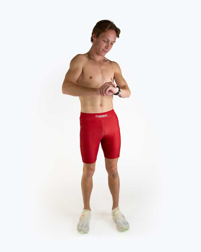 Full body view of model wearing ChicknLegs Men’s 8-inch Half Tights with soft elastic waistband, dual side pockets, internal key pocket, and black mesh liner for support and chafe-free performance.