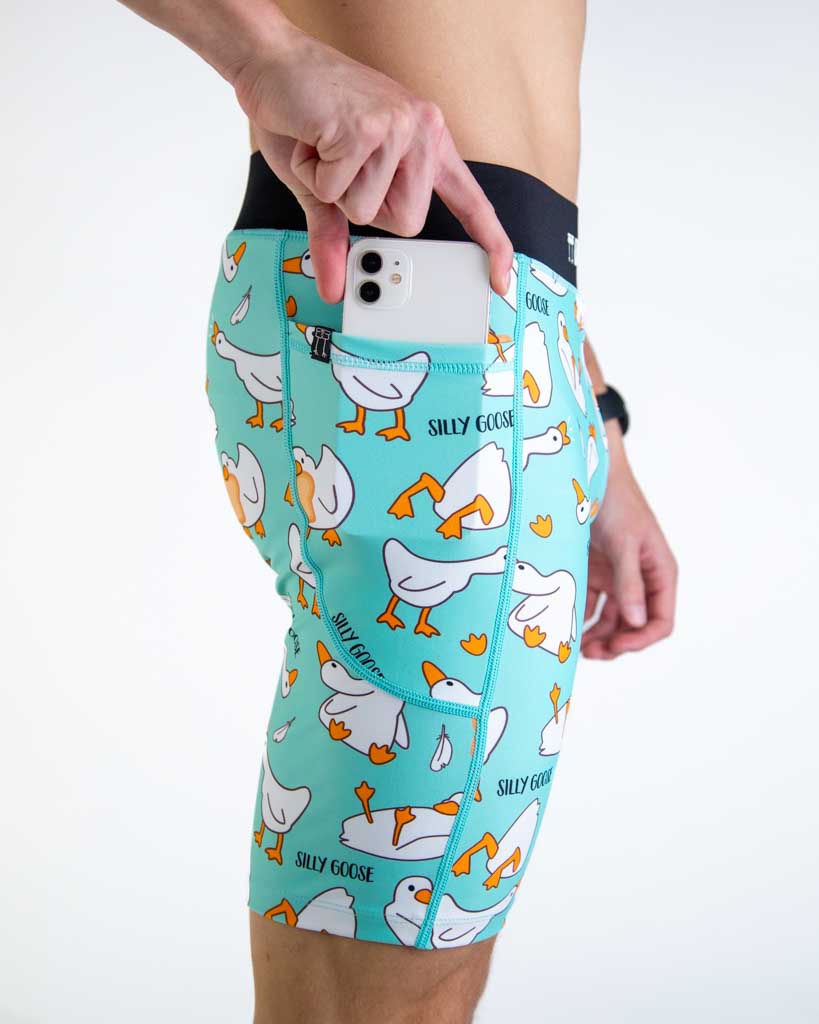 Close-up detail of ChicknLegs Men’s 8-inch Half Tights fabric and close up shot of the side pocket while the runner places a phone in the pocket.