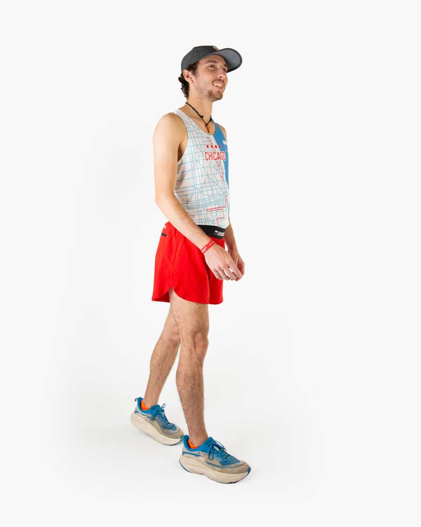 Full body view of model wearing ChicknLegs performance running singlet in the Chicago Marathon map route design, styled with red running shorts and shoes.