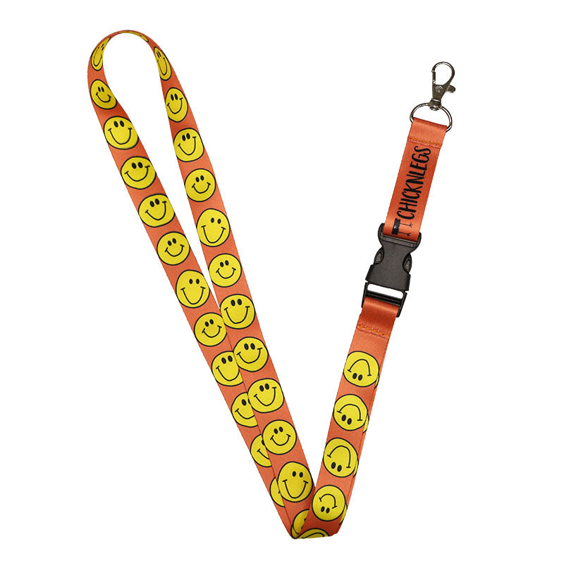 ChicknLegs lanyard with redish orange background and yellow smiley faces.