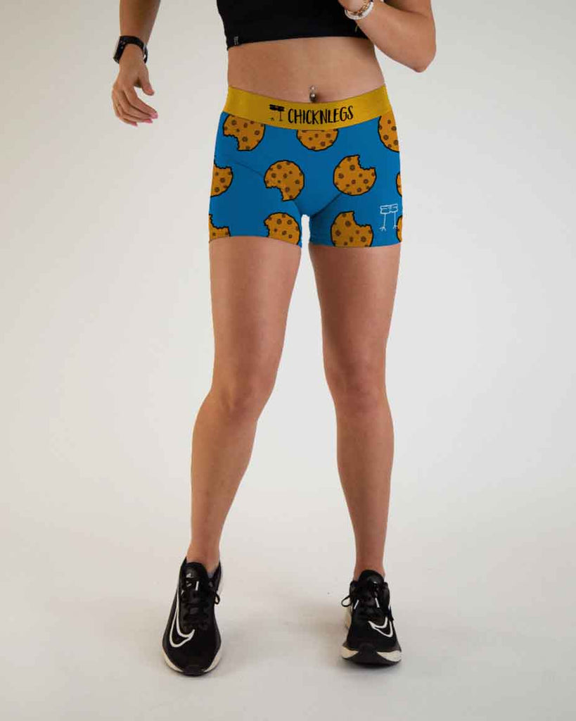 Runner is wearing ChicknLegs in the women's 3 in compression spandex shorts with side panel pockets that fit high rise on the waist. The print has chocolate chip cookies with a blue background.