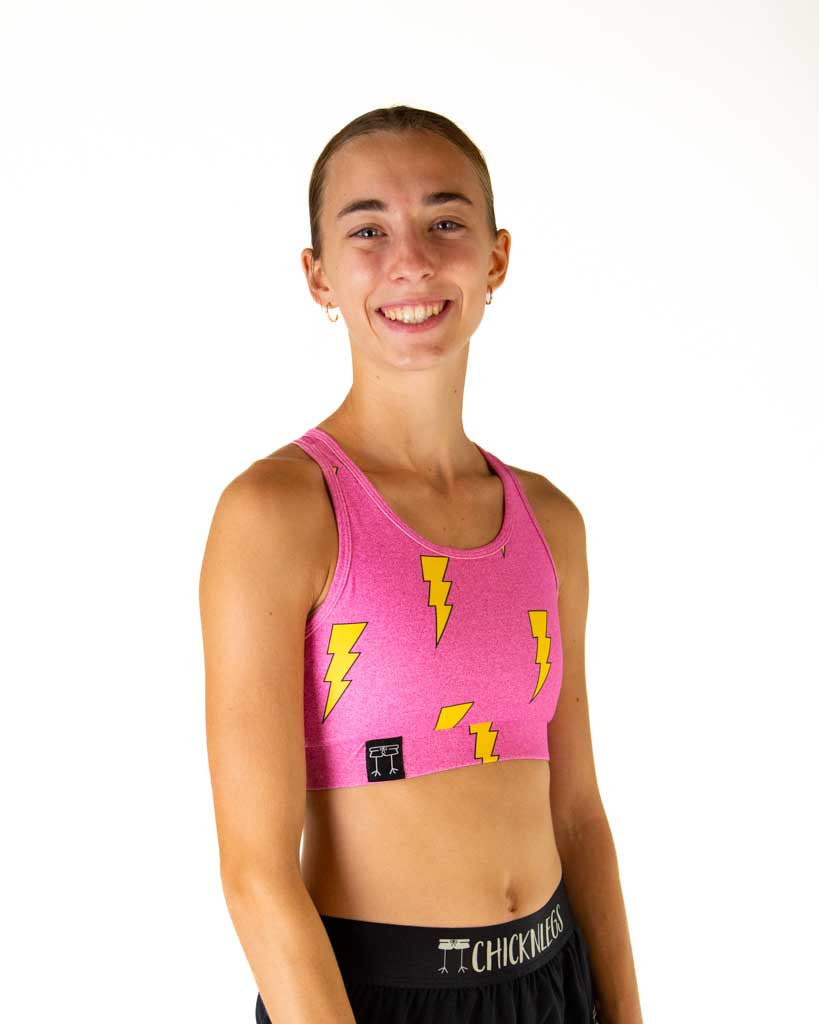 Right side view of ChicknLegs women’s OG sports bra in hot pink bolts with yellow lightning bolts, highlighting the logo on the under band.