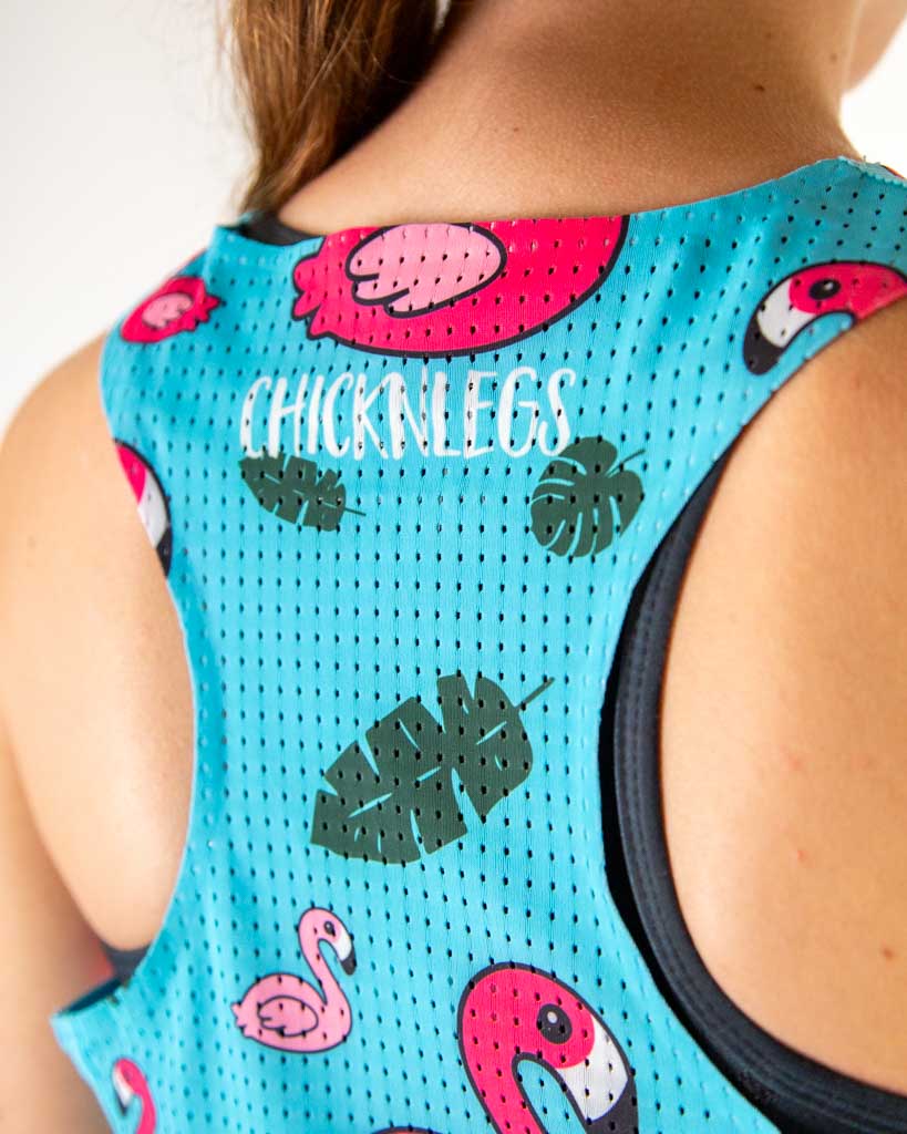 A close up shot is shown of the image of the runner wearing ChicknLegs in the women's performance singlet in the blue flamingo print. A breathable mesh back is shown.