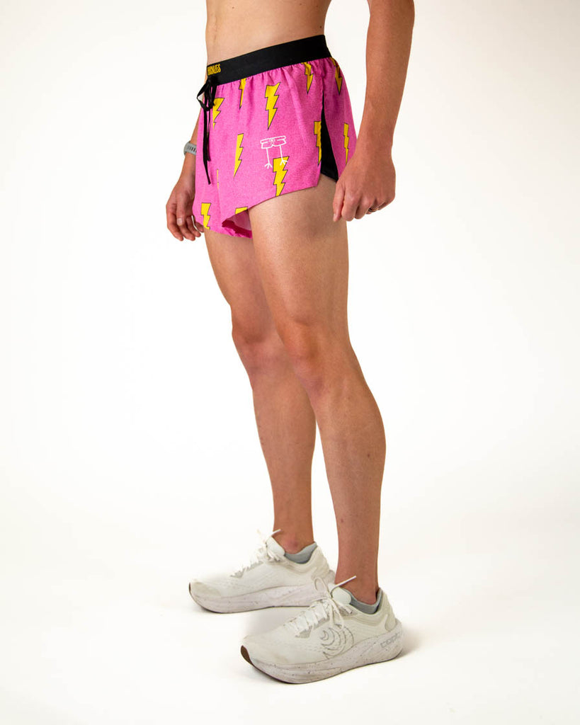 Left side view of ChicknLegs men’s 2-inch split running shorts in hot pink with yellow lightning bolts, featuring split leg design for running.