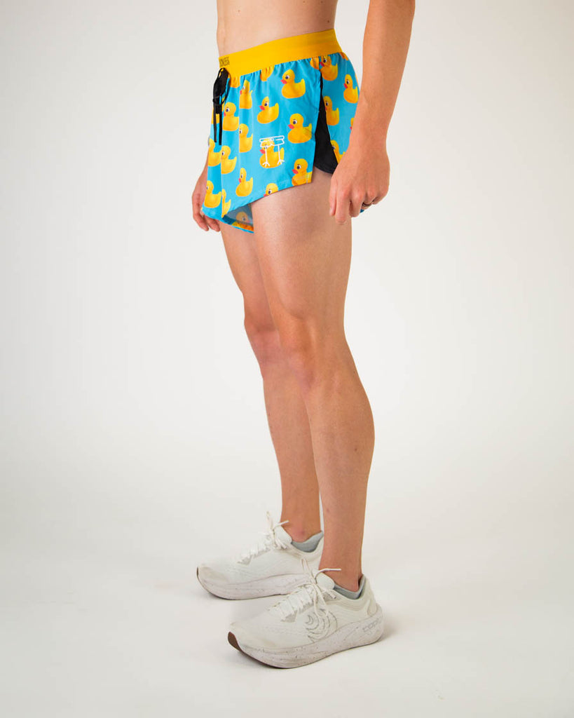Left side view of ChicknLegs men’s 2-inch split running shorts in blue with yellow rubber ducky, featuring split leg design for running.