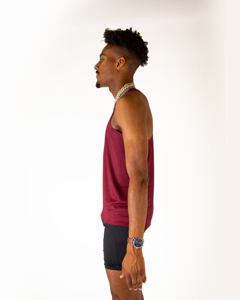 Runner is wearing ChicknLegs in the men's performance singlet in the maroon solid. Left side is shown.