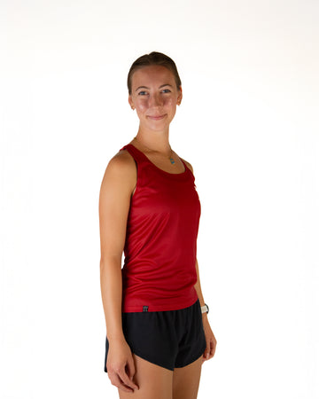 Runner is wearing ChicknLegs in the women's performance running singlet in the cardinal red solid color. Right view is shown to show the sides.