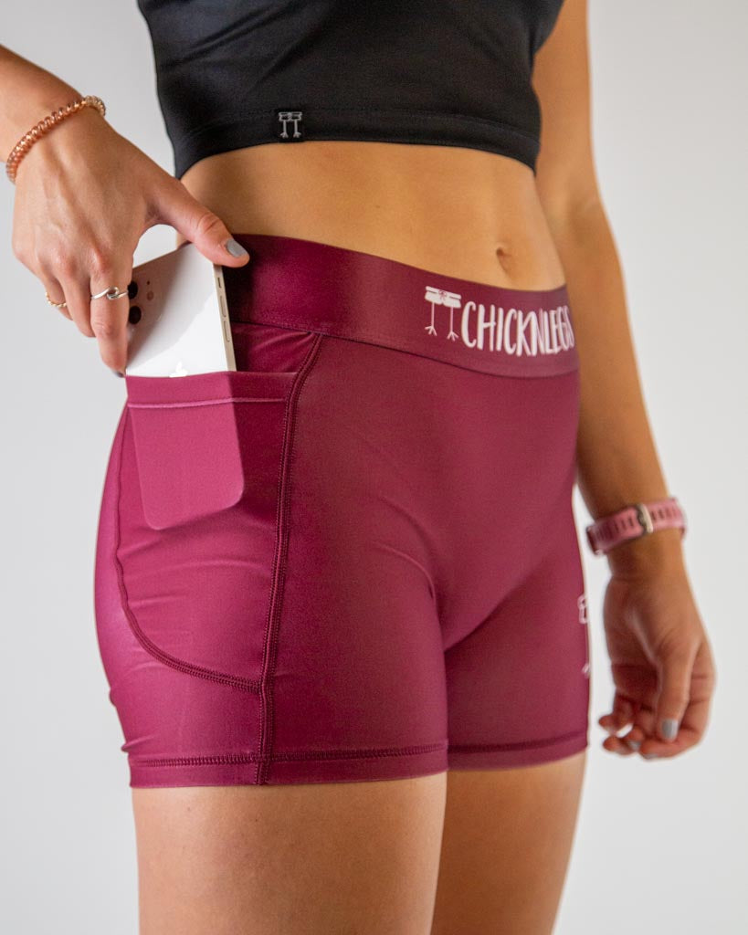 Close-up detail of ChicknLegs women’s 3-inch compression shorts, solid maroon fabric and side pocket stitching.
