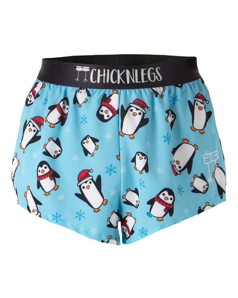 These shorts are from Chicknlegs in the men's 2 in split running shorts in the slippery bois design, as a ghost image. These shorts have penguins all over them for chistmas. These penguins are dressed in scarves, scarf, hat, and santa hats. With snowflakes and a light blue background.