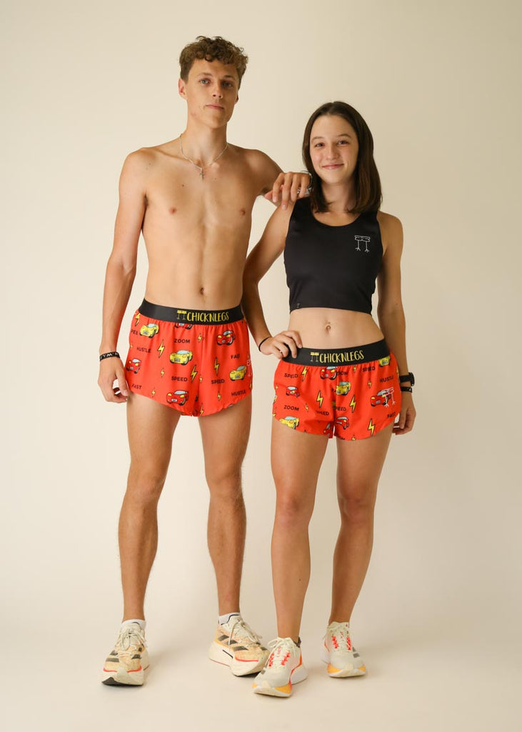 Model wearing Chicknlegs women's 1.5 inch split running shorts in the cars design posing with male model wearing Chicknlegs 2 inch split running shorts.