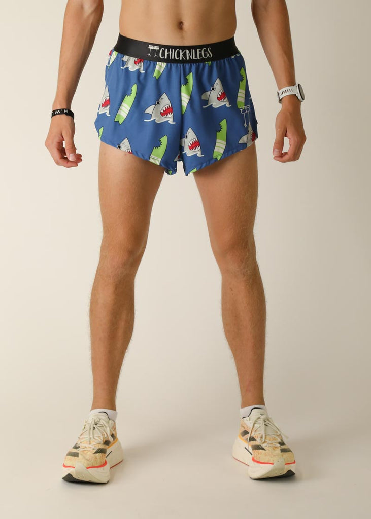 Model wearing Chicknlegs men's 2 inch split running shorts in the blue sharks design, facing front for front view.