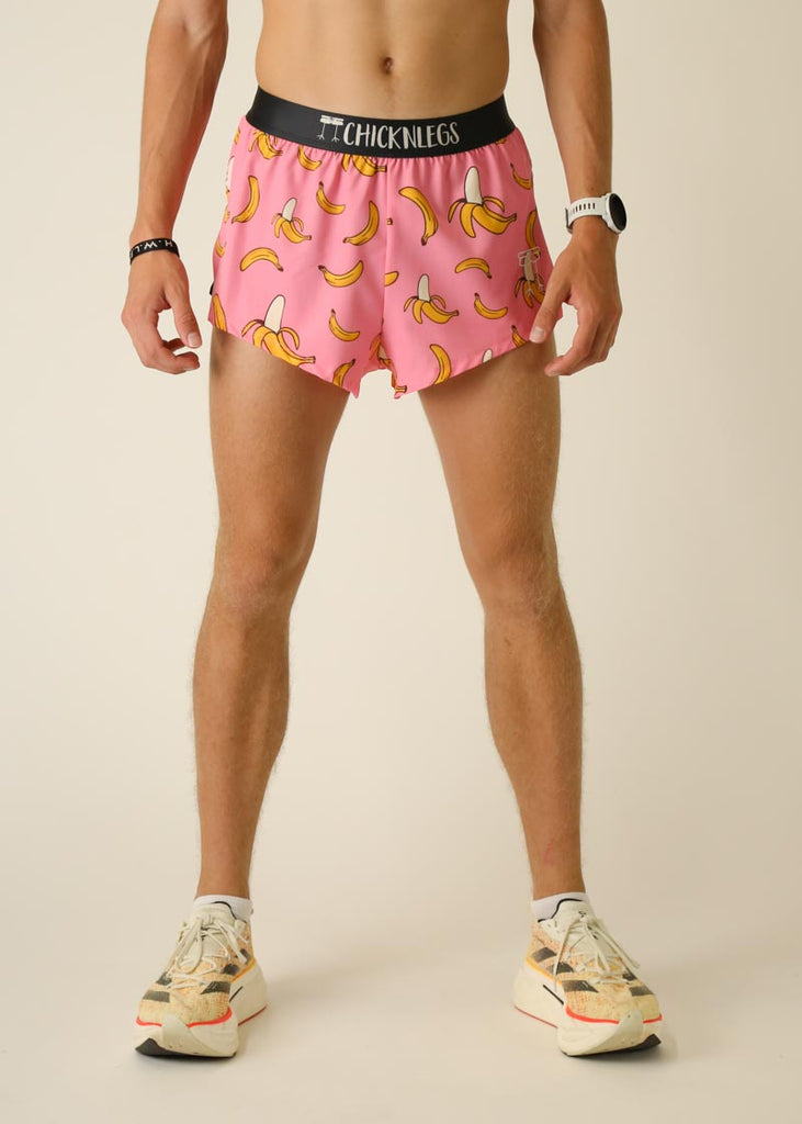 Model wearing Chicknlegs men's 2 inch split running shorts in the pink bananas design, facing front.