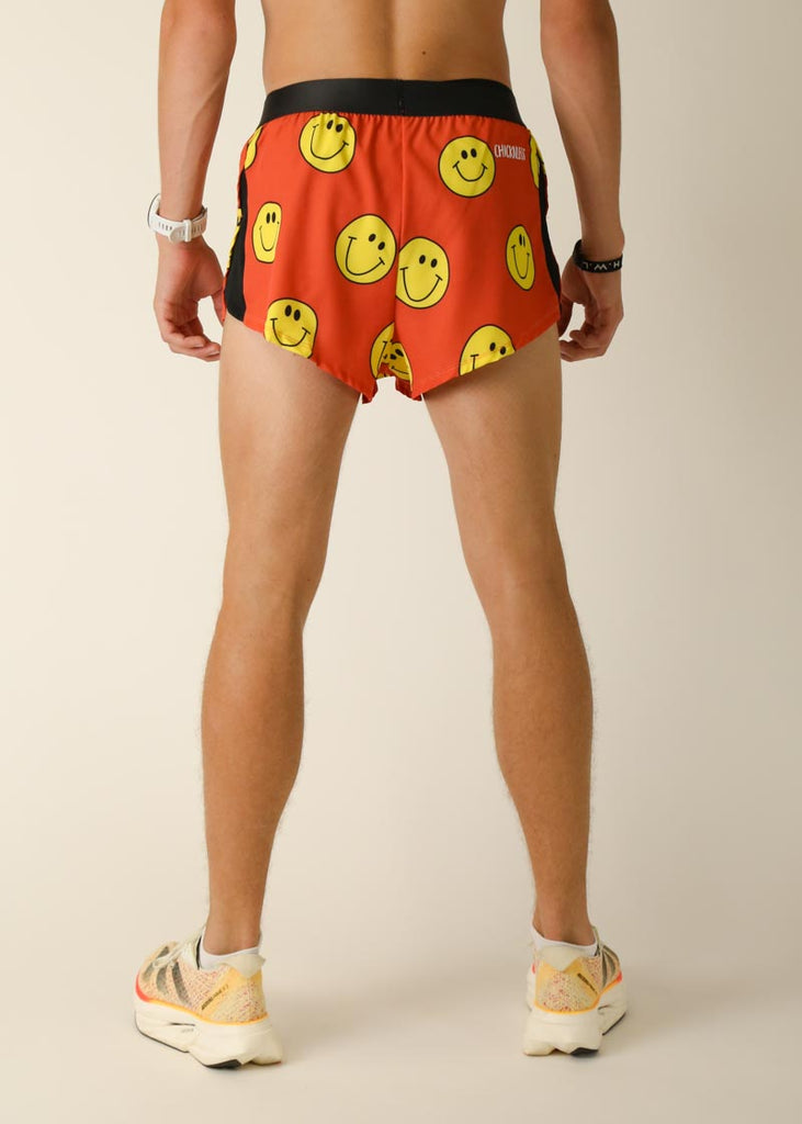 Model wearing Chicknlegs men's 2 inch split running shorts in the smiley, facing back for back view.