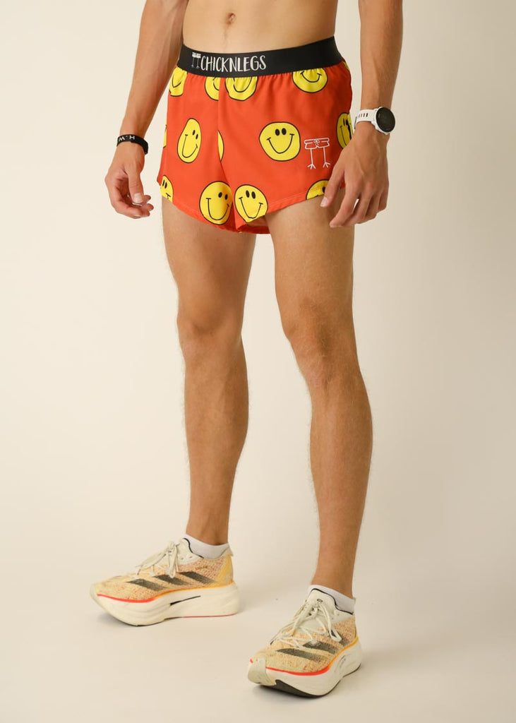 Model wearing Chicknlegs men's 2 inch split running shorts in the smiley, facing left for left side view.