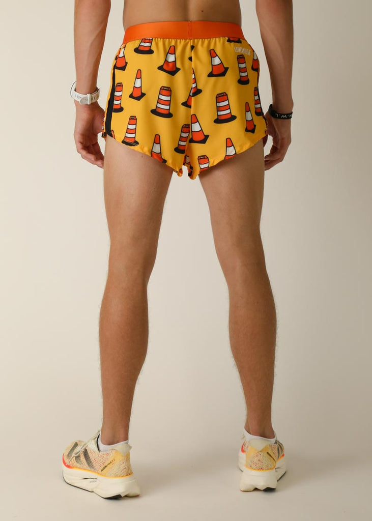 Model wearing Chicknlegs men's 2 inch split running shorts in the traffic cones design, facing back.